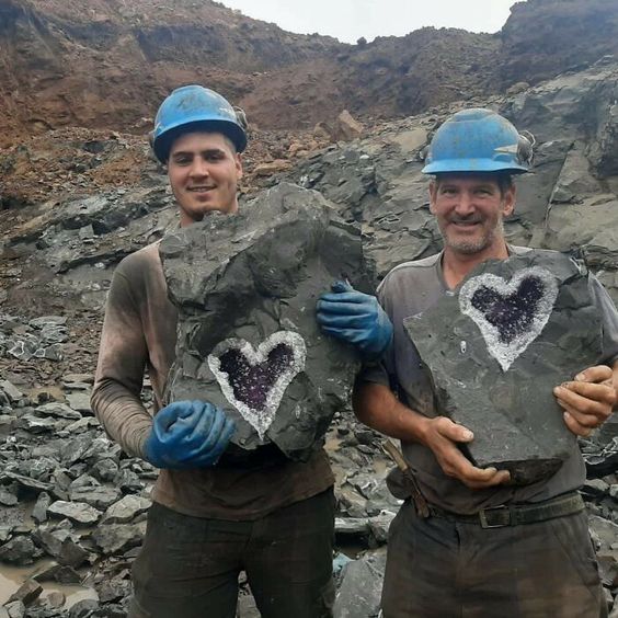 two guys holding heart shaped rocks